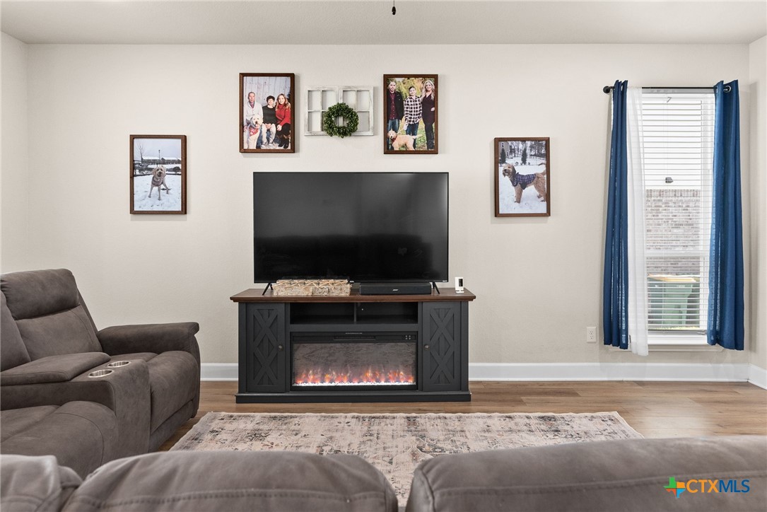 5712 Redfish Court Belton, TX 76513 - Photo 11 of 37 a living room with furniture a flat screen tv and a fireplace