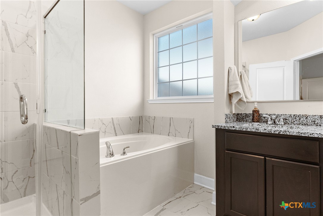 5712 Redfish Court Belton, TX 76513 - Photo 22 of 37 a bathroom with a granite countertop sink and a bathtub