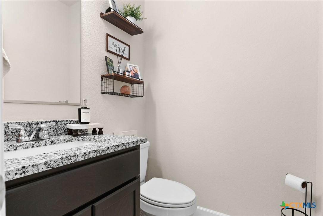 5712 Redfish Court Belton, TX 76513 - Photo 5 of 37 a bathroom with a granite countertop sink a toilet and mirror