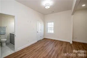 wooden floor in an empty room with a bathroom