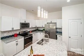 a kitchen with granite countertop a sink stainless steel appliances and cabinets