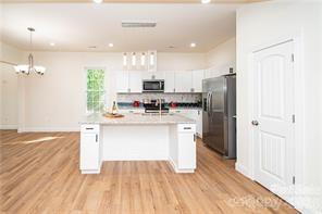 115 West Lacy Street Chester, SC 29706 - Photo 5 of 47 a kitchen with stainless steel appliances a refrigerator stove microwave and cabinets