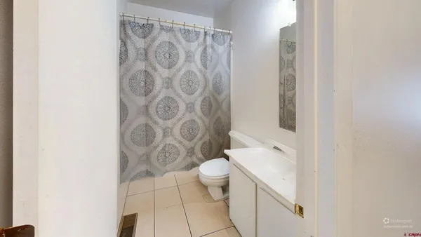 a bathroom with a shower curtain and a toilet