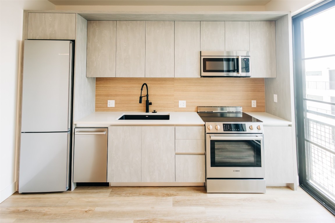 4315 South Congress Avenue, Unit 406 Austin, TX 78745 - Photo 4 of 19 a kitchen with stainless steel appliances white cabinets and a refrigerator