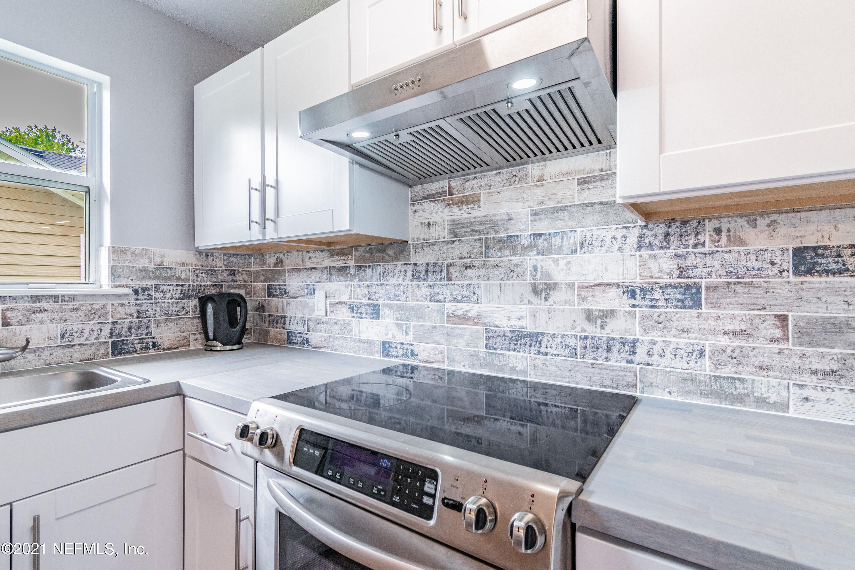 2154 Brooklyn Road Jacksonville, FL 32209 - Photo 12 of 37 a kitchen with granite countertop a stove a sink and white cabinets