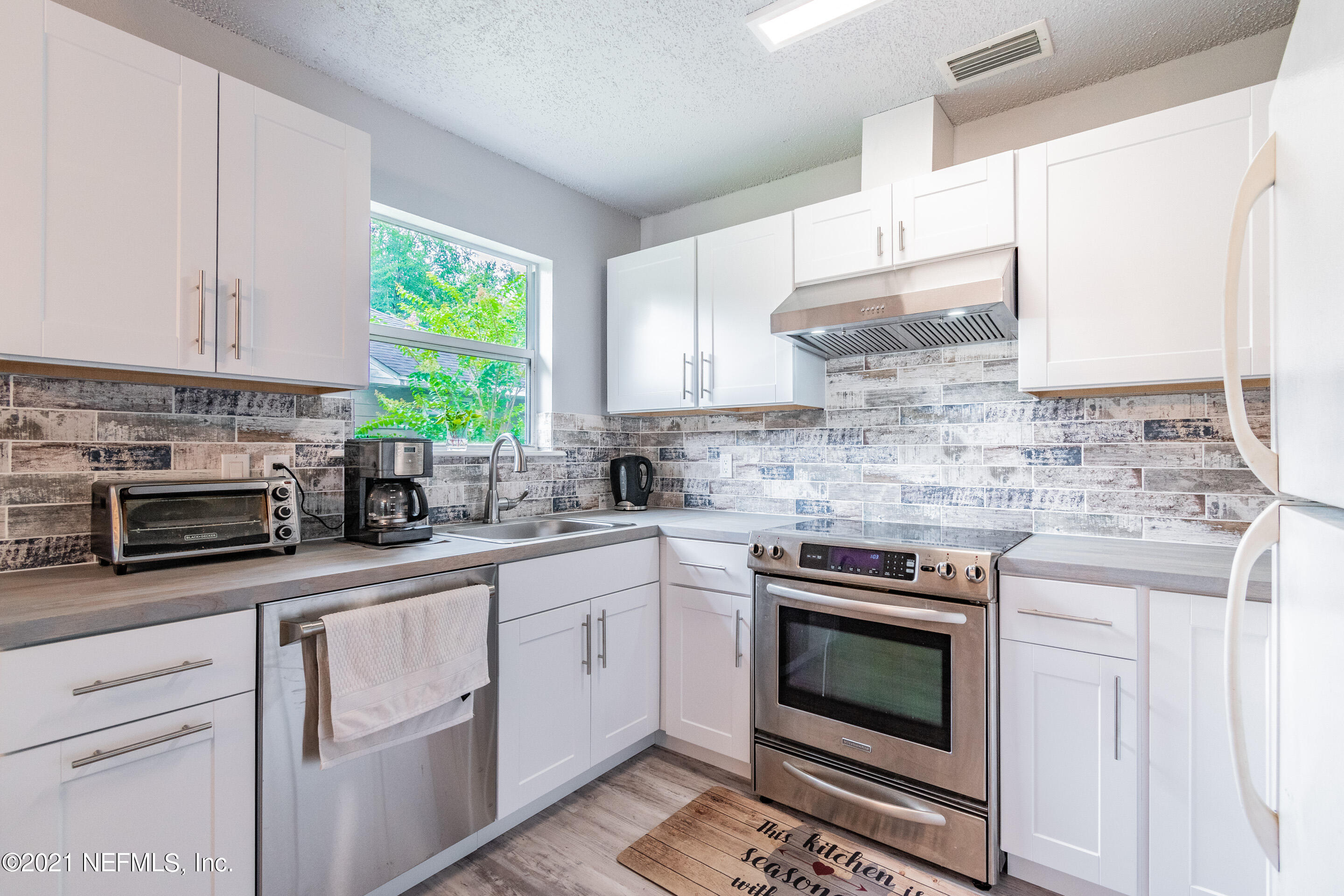 2154 Brooklyn Road Jacksonville, FL 32209 - Photo 9 of 37 a kitchen with stainless steel appliances granite countertop white cabinets a stove a sink and a microwave