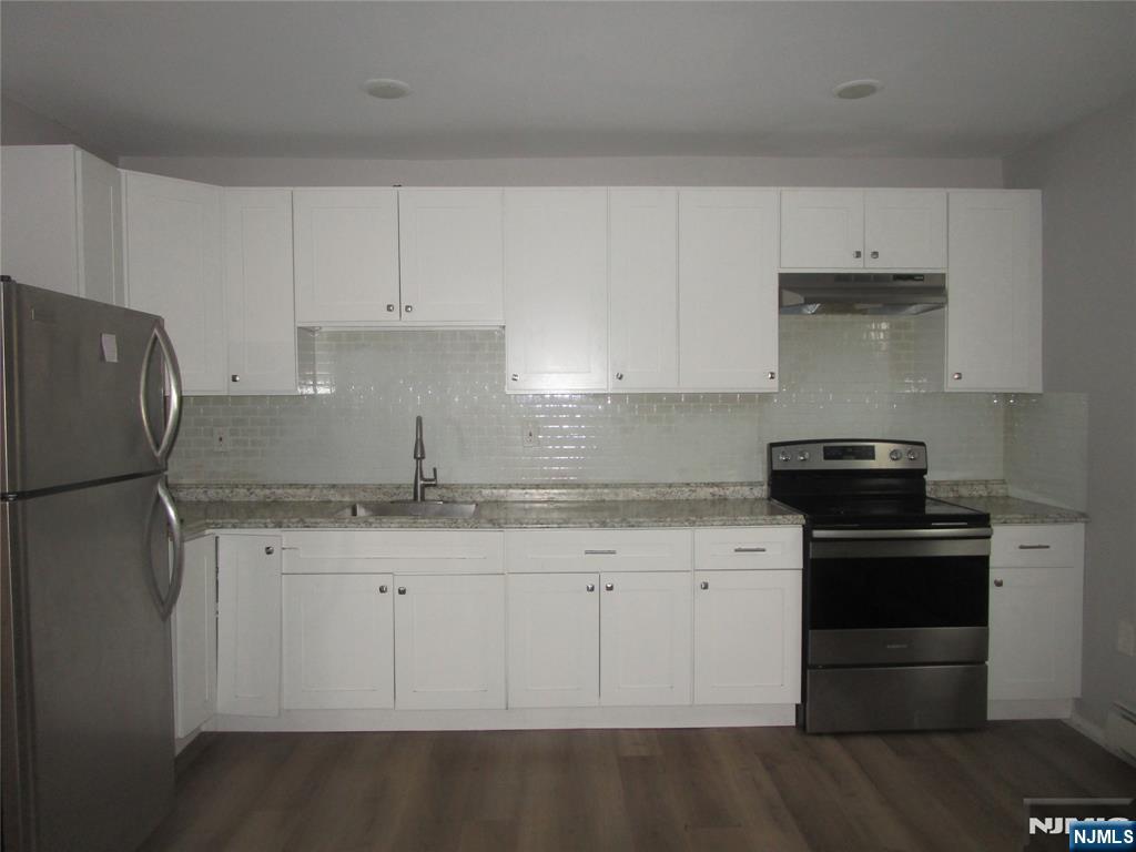 437 7th Avenue Newark, NJ 07107 - Photo 3 of 7 a kitchen with granite countertop white cabinets and stainless steel appliances