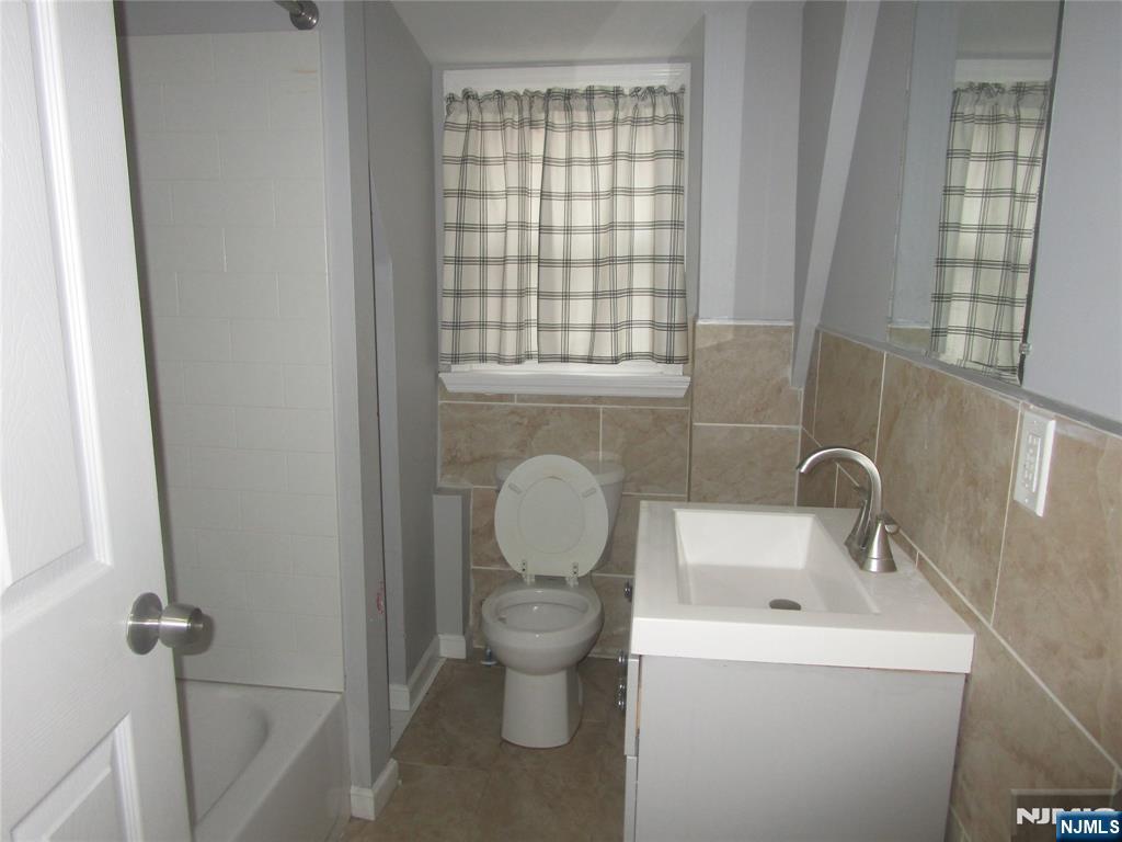 437 7th Avenue Newark, NJ 07107 - Photo 4 of 7 a bathroom with a toilet sink and mirror