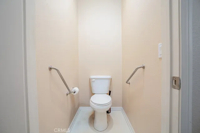 a bathroom with a granite countertop toilet sink and mirror