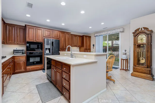 a kitchen with granite countertop wooden cabinets a dining table and chairs
