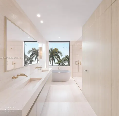 a bathroom with a tub a sink and a large mirror