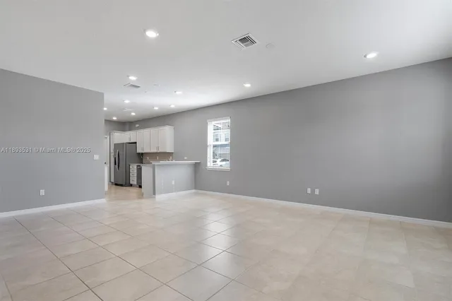 a view of an empty room with a kitchen