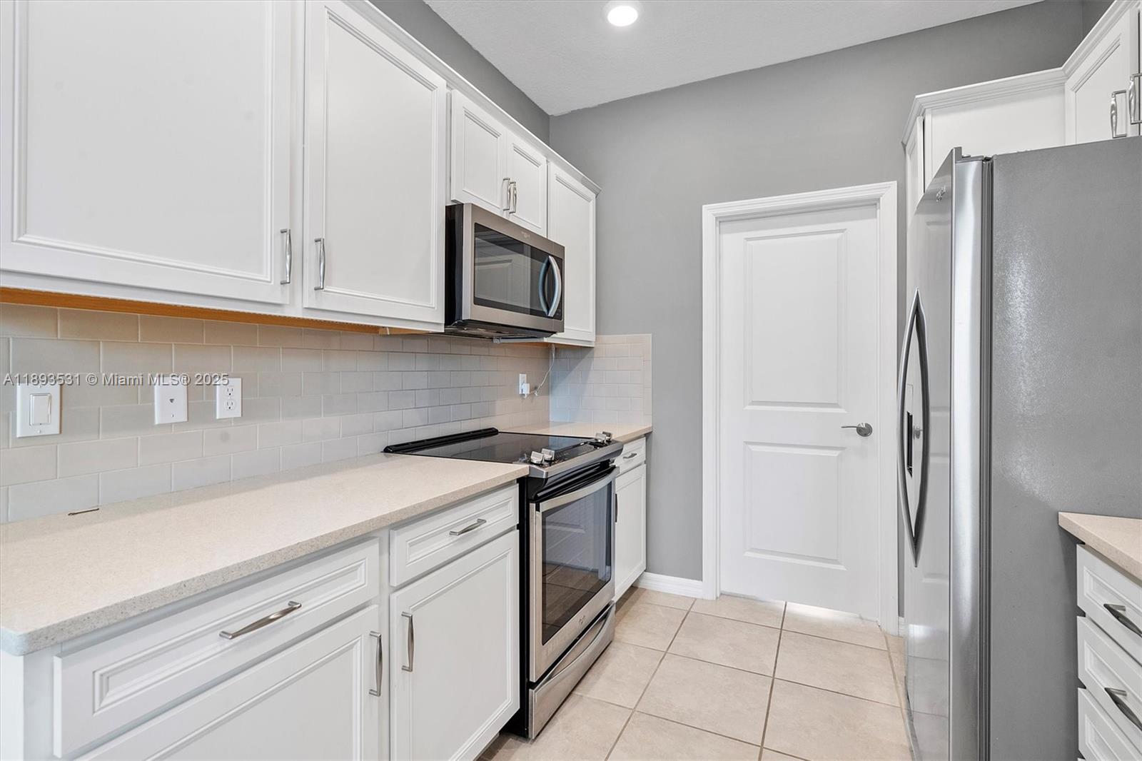 1240 Eucalyptus Drive, Unit 1 Hollywood, FL 33021 - Photo 3 of 20 a kitchen with white cabinets and stainless steel appliances