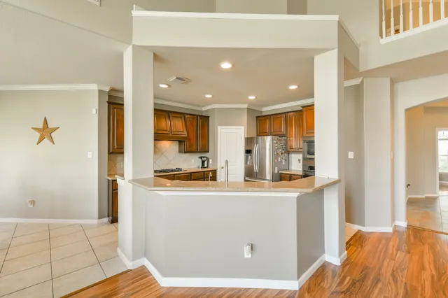 a kitchen with stainless steel appliances granite countertop a refrigerator and a stove top oven