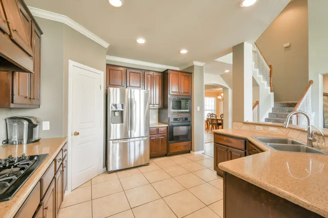 a kitchen with stainless steel appliances granite countertop a refrigerator and a sink