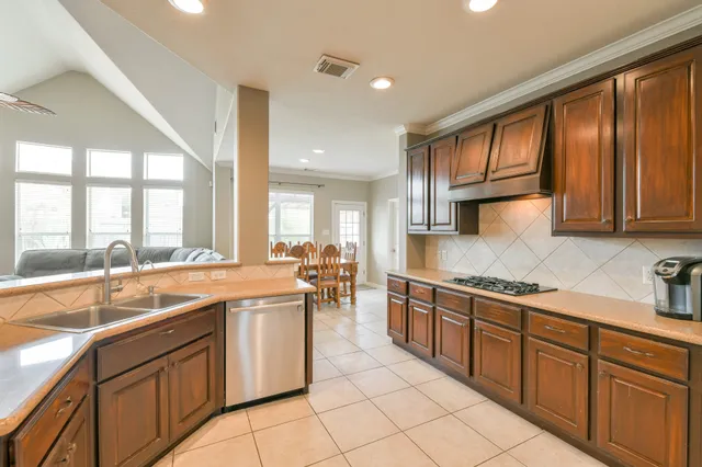 a large kitchen with stainless steel appliances granite countertop a sink and cabinets