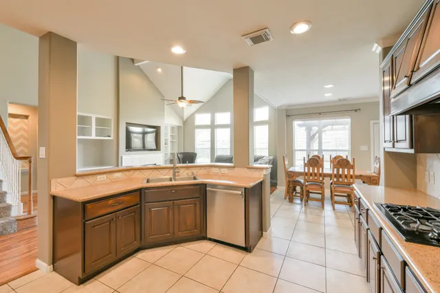 a kitchen with a sink and chairs