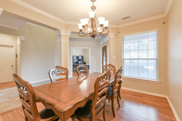a dining room with furniture a chandelier and wooden floor