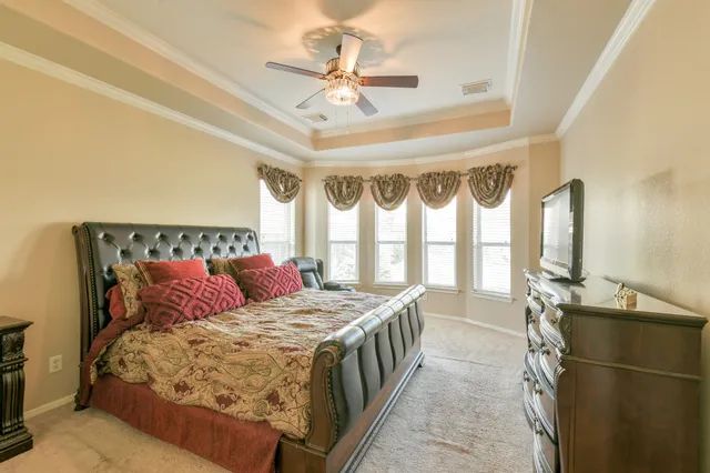 a bedroom with a large bed and a chandelier