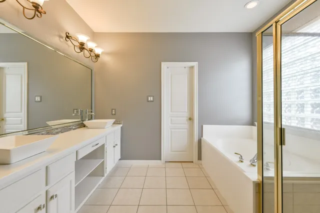 a bathroom with a tub sink and mirror