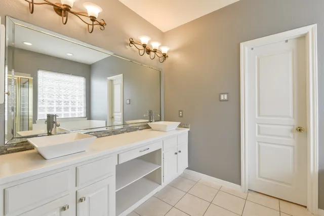 a bathroom with a granite countertop sink a large mirror and a bathtub