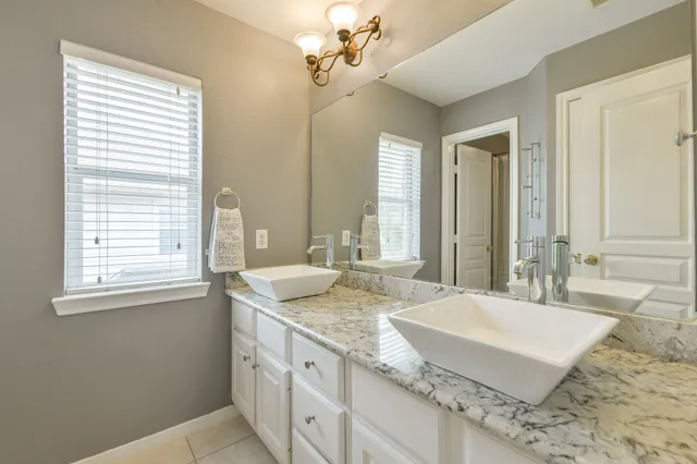 a bathroom with sinks granite countertop double vanity sink a mirror and a bathtub