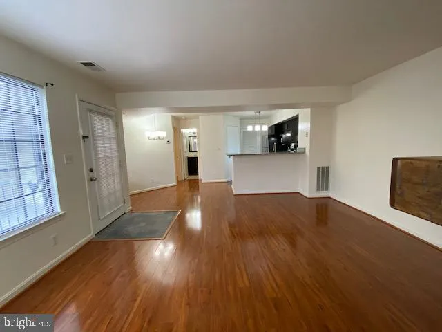 a view of a big room with wooden floor and windows