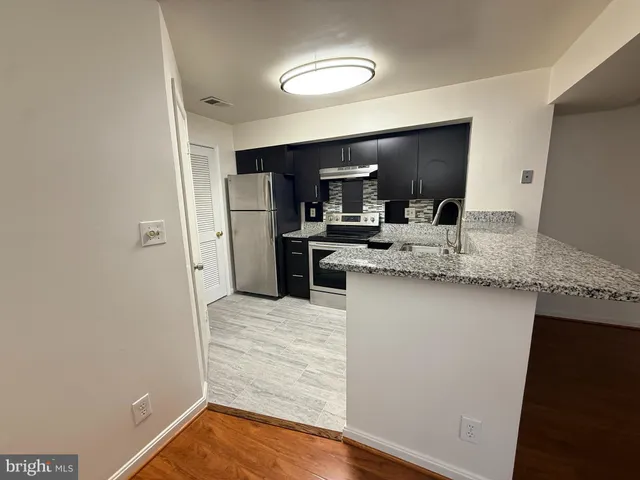 a kitchen with stainless steel appliances granite countertop a sink refrigerator and microwave