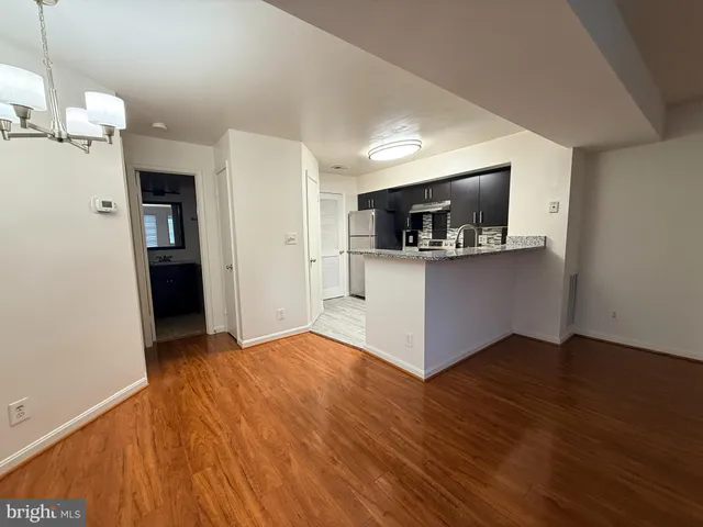 a view of a kitchen with wooden floor and a ceiling fan