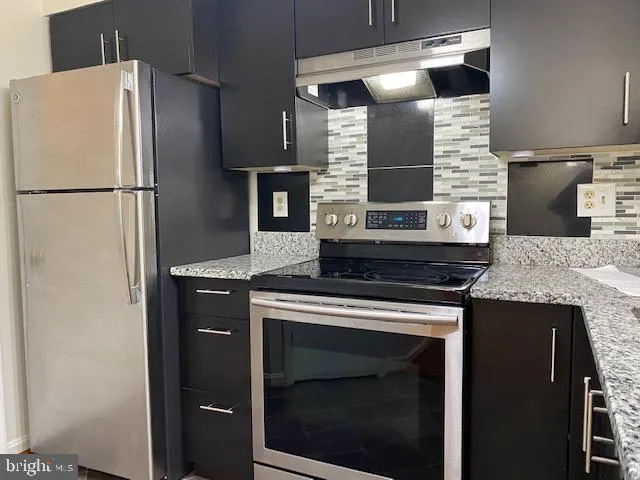 a stove top oven sitting inside of a kitchen