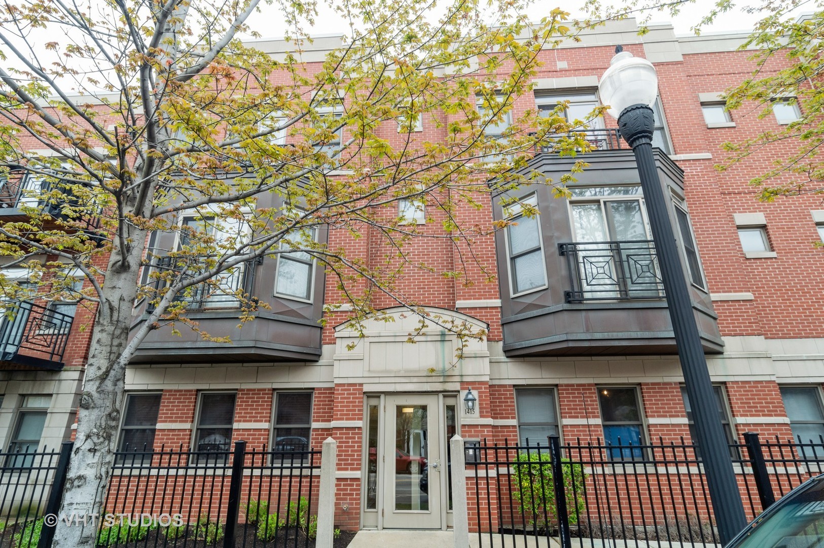 a view of a brick building next to a large tree