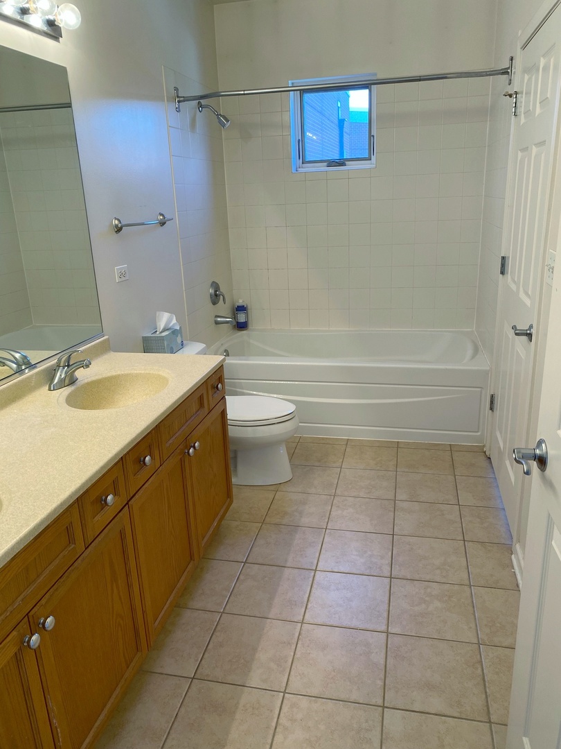 1415 South Halsted Street, Unit 3A Chicago, IL 60607 - Photo 10 of 14 a bathroom with a granite countertop sink a toilet and shower