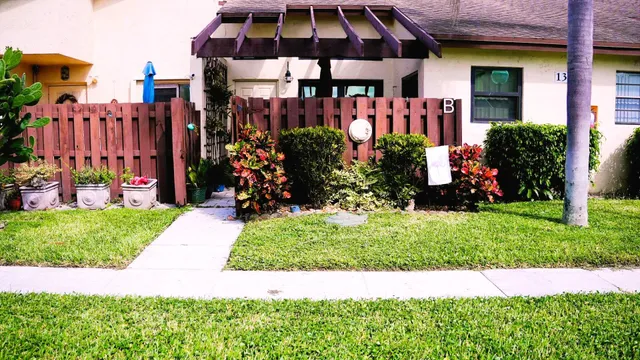 a view of a house with a yard and flower plants
