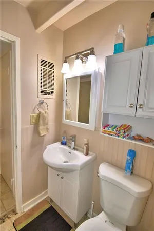 a bathroom with a toilet sink and mirror