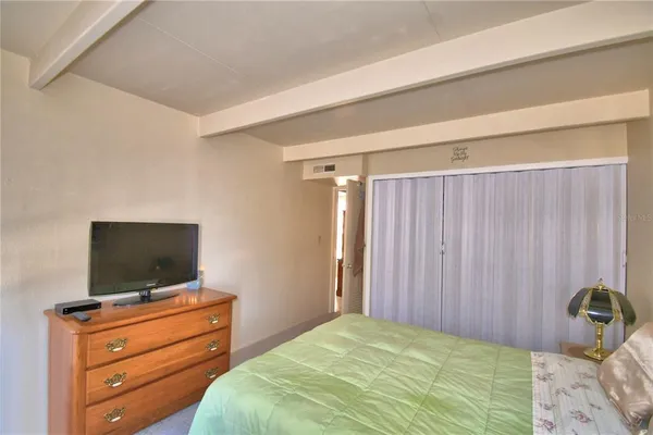 a bedroom with a bed and flat screen tv