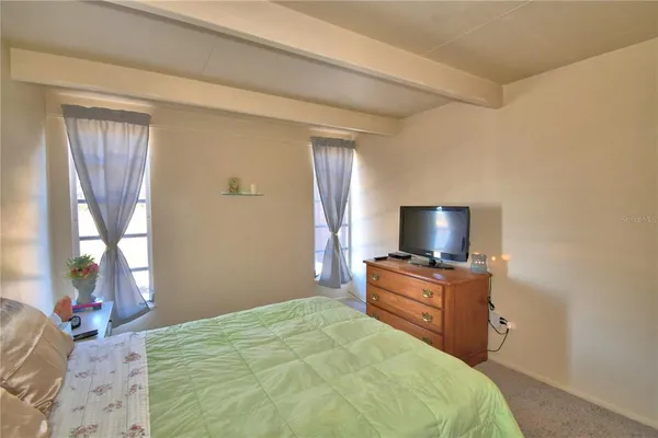 a bedroom with a bed and flat screen tv