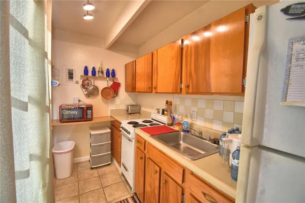 a view of a kitchen with a sink and dishwasher a stove with wooden floor