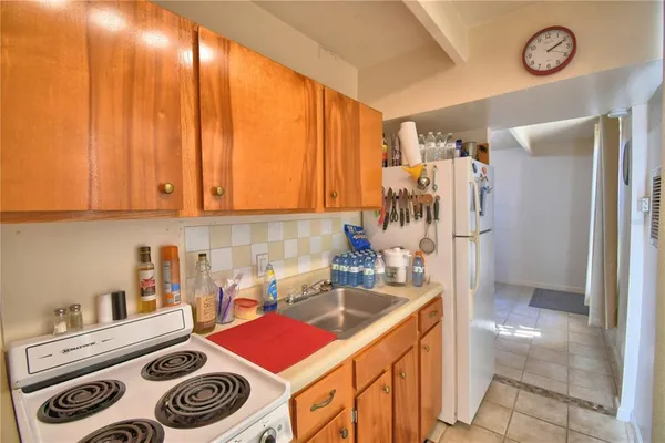 a kitchen with a refrigerator and a stove top oven