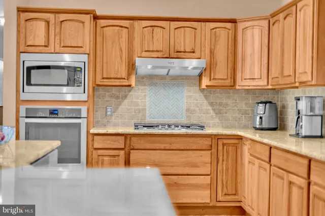 a kitchen with granite countertop cabinets stainless steel appliances and a counter space