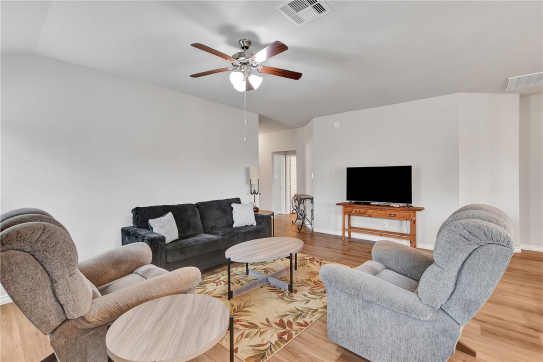 909 Davy Street Brenham, TX 77833 - Photo 10 of 35 Living area featuring light wood-style floors, ceiling fan, and vaulted ceiling