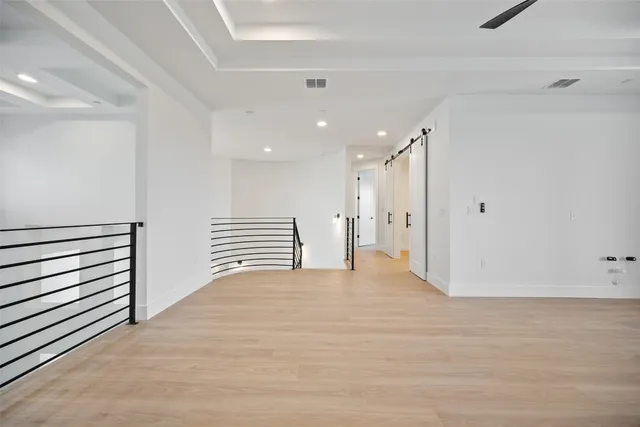 a view of an empty room with wooden floor