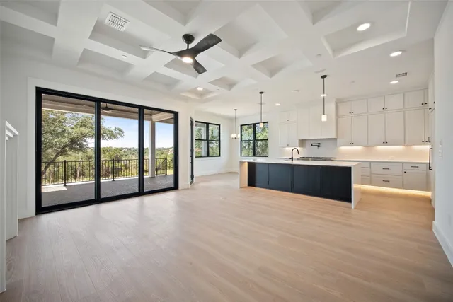 a large kitchen with kitchen island white cabinets and stainless steel appliances
