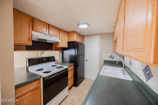 a kitchen that has a lot of cabinets a sink and a stove in it