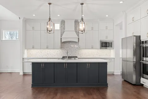 a kitchen with a refrigerator sink and cabinets
