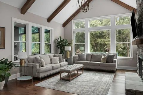 a view of swimming pool with seating space and trees in the background