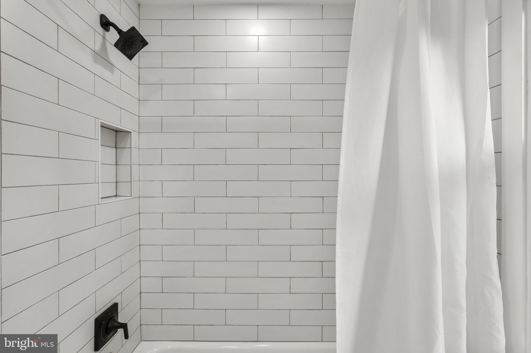 9409 Garwood Street Silver Spring, MD 20901 - Photo 33 of 49 Sleek, modern shower/tub with white tiles.