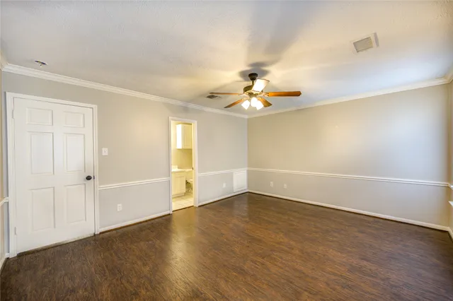 an empty room with wooden floor and chandelier fan
