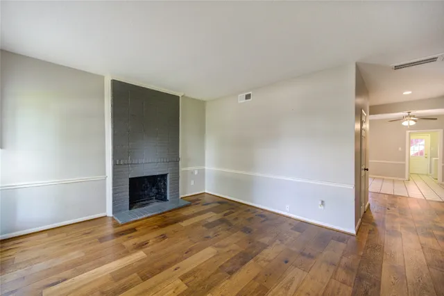 a view of empty room with wooden floor and fireplace