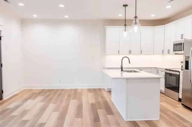 a kitchen with kitchen island a sink stainless steel appliances and cabinets