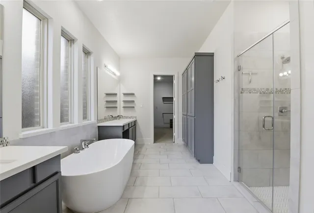 a bathroom with a double vanity sink a mirror and a bathtub